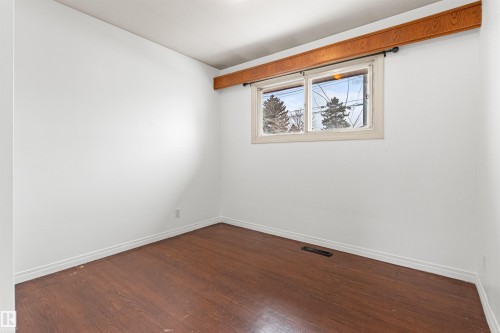 This room features dark wood flooring and a window with a wooden frame - 8608 156 Street, Edmonton, AB - Indoor Photo Showing Other Room