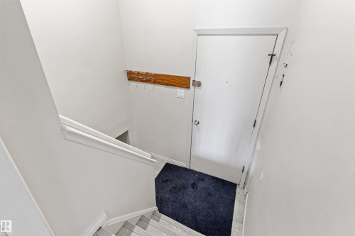 Entryway featuring a staircase with a white railing, a white door, and a wall-mounted wooden rack with hooks - 8608 156 Street, Edmonton, AB - Indoor Photo Showing Other Room