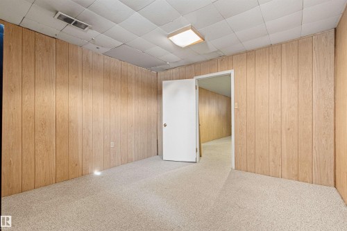 This room features light-colored carpeting and wood paneling on the walls - 8608 156 Street, Edmonton, AB - Indoor Photo Showing Other Room