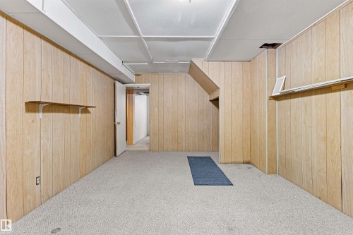 The interior space features light-colored wood paneling on the walls and a light-colored carpet, providing a neutral aesthetic - 8608 156 Street, Edmonton, AB - Indoor Photo Showing Other Room