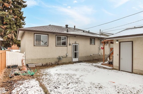 The property includes a detached structure with a white door and an exterior light fixture, and a yard area - 8608 156 Street, Edmonton, AB - Outdoor With Exterior