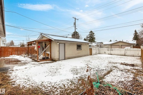 The property includes a detached structure with a pitched roof and a side door, situated within a fenced yard - 8608 156 Street, Edmonton, AB - Outdoor