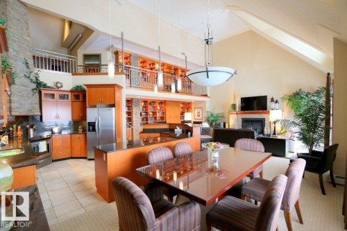 Dining area with high vaulted ceiling, light tile patterned floors, and a fireplace - 1402 9707 105 Street, Edmonton, AB - Indoor Photo Showing Dining Room With Fireplace