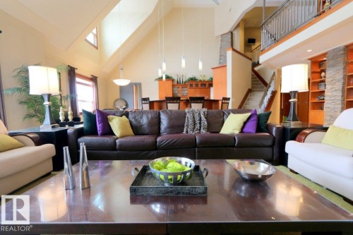 Living area featuring high vaulted ceiling, built in features, and stairway - 1402 9707 105 Street, Edmonton, AB - Indoor Photo Showing Living Room