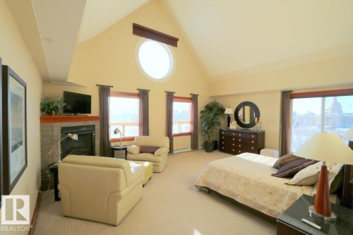 Bedroom featuring high vaulted ceiling, a fireplace, and carpet - 1402 9707 105 Street, Edmonton, AB - Indoor With Fireplace