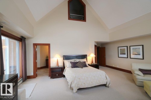 Bedroom with high vaulted ceiling, light carpet, and a baseboard heating unit - 1402 9707 105 Street, Edmonton, AB - Indoor Photo Showing Bedroom