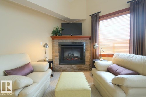 Living room featuring a fireplace and carpet flooring - 1402 9707 105 Street, Edmonton, AB - Indoor Photo Showing Living Room With Fireplace