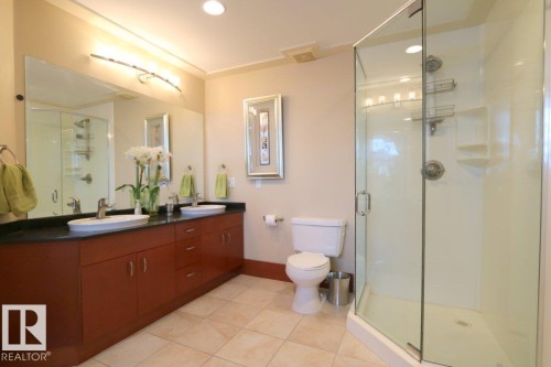 Full bath featuring a stall shower, double vanity, light tile patterned floors, and recessed lighting - 1402 9707 105 Street, Edmonton, AB - Indoor Photo Showing Bathroom