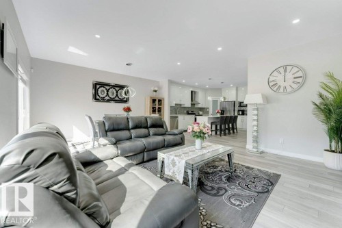 Open concept living space featuring light-colored flooring, recessed lighting, and a view of the kitchen with a breakfast bar - 452 Roberts Crescent, Leduc, AB - Indoor Photo Showing Living Room
