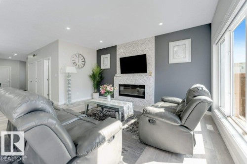 Living area featuring light-colored flooring, recessed lighting, and large windows providing natural light - 452 Roberts Crescent, Leduc, AB - Indoor Photo Showing Living Room With Fireplace