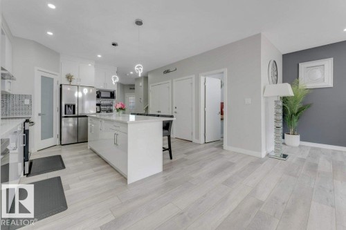 The kitchen features white cabinetry, stainless steel appliances, an island with seating, and recessed lighting - 452 Roberts Crescent, Leduc, AB - Indoor Photo Showing Kitchen With Upgraded Kitchen