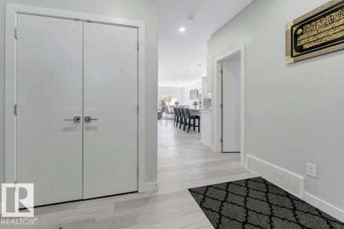 Entryway featuring light-colored flooring, white walls, and a pair of white doors with modern handles - 452 Roberts Crescent, Leduc, AB - Indoor Photo Showing Other Room