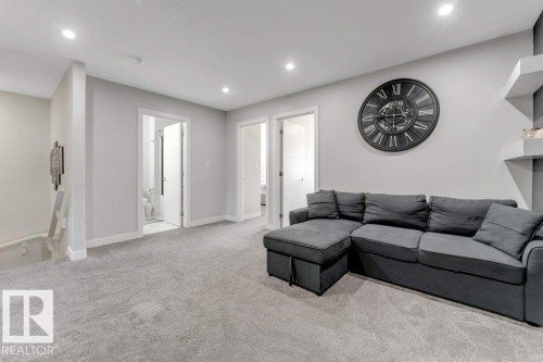 This versatile living space features light gray carpeting, recessed lighting, and a neutral wall color throughout - 452 Roberts Crescent, Leduc, AB - Indoor Photo Showing Living Room