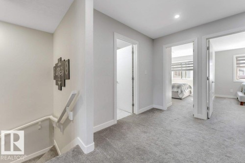 Upper landing featuring light grey carpeting, white trim, and white doors - 452 Roberts Crescent, Leduc, AB - Indoor Photo Showing Other Room