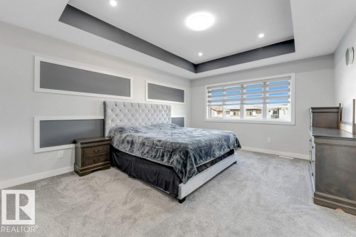 The bedroom features light grey carpeting, recessed lighting, and a tray ceiling with a dark accent - 452 Roberts Crescent, Leduc, AB - Indoor Photo Showing Bedroom