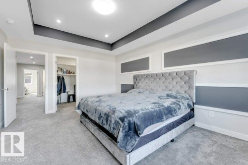 This room features light grey carpeting, recessed lighting, and an accent wall with grey paneling - 452 Roberts Crescent, Leduc, AB - Indoor Photo Showing Bedroom
