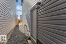 The exterior of the property features horizontal siding, a door with a wooden step, and a wall-mounted light fixture - 452 Roberts Crescent, Leduc, AB  - Outdoor With Exterior 