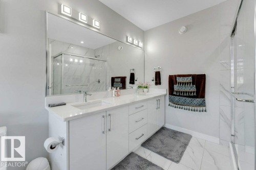 The bathroom features a spacious vanity with dual sinks and a large mirror, complemented by modern overhead lighting - 452 Roberts Crescent, Leduc, AB - Indoor Photo Showing Bathroom