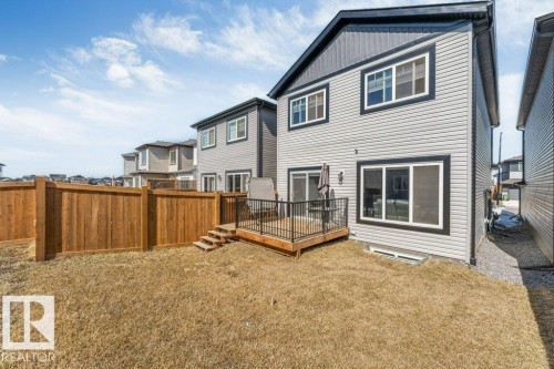 The property features a fenced yard with a wooden deck and exterior stairs - 452 Roberts Crescent, Leduc, AB - Outdoor With Exterior