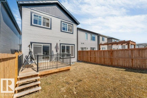 The property features a wooden deck with black railings, accessible via exterior wooden steps - 452 Roberts Crescent, Leduc, AB - Outdoor With Exterior
