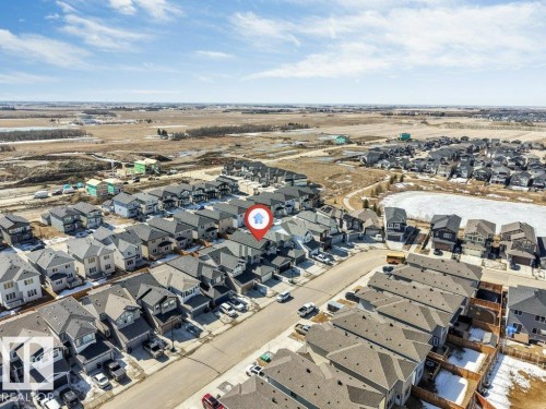 Aerial view of a residential neighbourhood with a street lined with houses and a body of water in the background - 452 Roberts Crescent, Leduc, AB - Outdoor With View