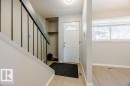 Inviting entryway with a white door featuring a decorative glass insert, light-colored flooring, and a built-in coat closet area - 12032 25 Avenue, Edmonton, AB  - Indoor Photo Showing Other Room 