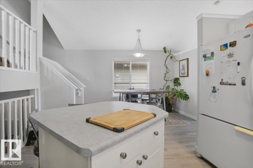 The kitchen features a white refrigerator and an island with a light-colored countertop - 3119 32 Avenue, Edmonton, AB - Indoor