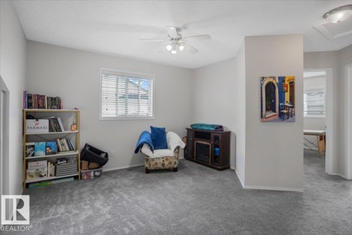 This room features light grey walls, grey carpet, a ceiling fan, and a window with horizontal blinds - 3119 32 Avenue, Edmonton, AB - Indoor