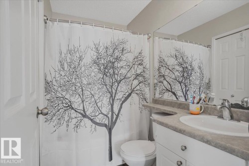 The bathroom features a vanity with a white basin sink and a mirror - 3119 32 Avenue, Edmonton, AB - Indoor Photo Showing Bathroom