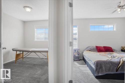 This space offers two distinct areas, each featuring light-colored walls and grey carpeting - 3119 32 Avenue, Edmonton, AB - Indoor Photo Showing Bedroom