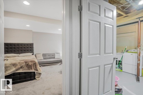The property features a finished interior space with recessed lighting and carpeting, offering a versatile area - 3119 32 Avenue, Edmonton, AB - Indoor Photo Showing Laundry Room