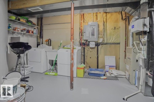 The utility area features a washer and dryer, laundry sink, electrical panel, and exposed ductwork - 3119 32 Avenue, Edmonton, AB - Indoor