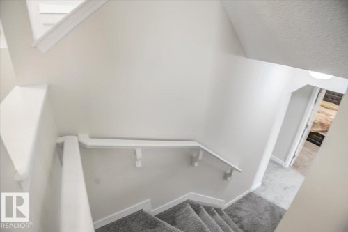 Staircase featuring carpeted steps and white handrails - 3119 32 Avenue, Edmonton, AB - Indoor