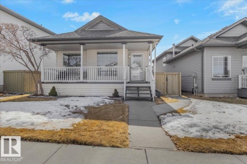 The property features a front porch with white railing, light-colored siding, and a gabled roof - 3119 32 Avenue, Edmonton, AB - Outdoor With Deck Patio Veranda