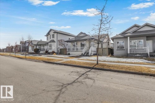 This property features a covered front porch with white railings and steps - 3119 32 Avenue, Edmonton, AB - Outdoor With Facade