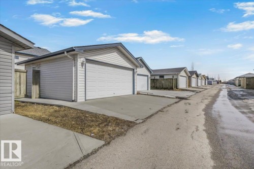 Attached garage with a concrete driveway and vinyl siding - 3119 32 Avenue, Edmonton, AB - Outdoor With Exterior