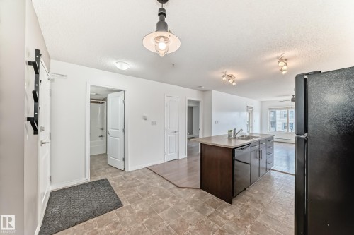 The open-concept living space features light-colored walls and tiled flooring - 301 103 Ambleside Drive, Edmonton, AB - Indoor