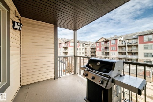 The property features a covered balcony with a concrete floor and dark metal railings - 301 103 Ambleside Drive, Edmonton, AB - Outdoor With Exterior