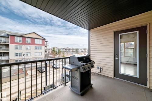 The property features a private balcony with a dark metal railing, offering exterior views of the surrounding area - 301 103 Ambleside Drive, Edmonton, AB - Outdoor With Exterior