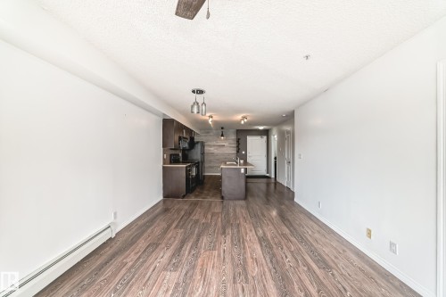 Open concept living space featuring wood-look flooring and white walls - 301 103 Ambleside Drive, Edmonton, AB - Indoor Photo Showing Other Room