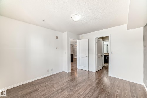 The property features wood-look flooring and white walls, with a ceiling light fixture - 301 103 Ambleside Drive, Edmonton, AB - Indoor Photo Showing Other Room