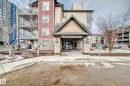 The property features a prominent entrance with a gabled roof and stone-clad pillars, creating a welcoming facade - 301 103 Ambleside Drive, Edmonton, AB  - Outdoor With Facade 