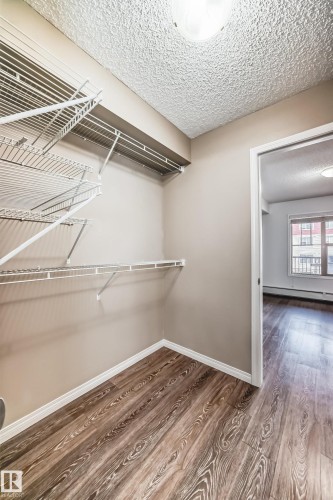 The closet features wire shelving, wood flooring, and neutral wall paint - 301 103 Ambleside Drive, Edmonton, AB - Indoor With Storage