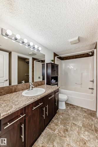 Bathroom featuring a vanity with a white oval sink, chrome faucet, and dark wood cabinetry with chrome handles - 301 103 Ambleside Drive, Edmonton, AB - Indoor Photo Showing Bathroom