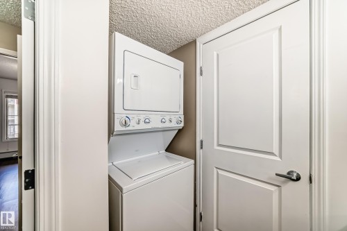 Laundry area featuring a stacked washer and dryer unit - 301 103 Ambleside Drive, Edmonton, AB - Indoor Photo Showing Laundry Room