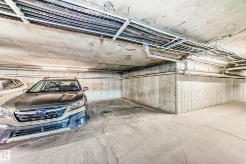Dedicated parking space with concrete walls and flooring, illuminated by overhead lighting - 301 103 Ambleside Drive, Edmonton, AB - Indoor Photo Showing Garage