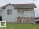 The property features a front lawn with a stone pathway, a wooden porch with white railings, and siding exterior - 1318 8 Avenue, Cold Lake, AB  - Outdoor 