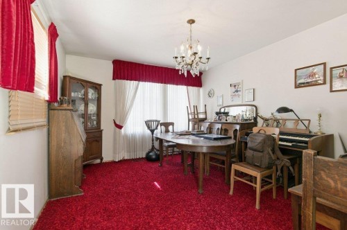 The room features red carpeting, white walls, and a chandelier - 10459 66 Avenue, Edmonton, AB - Indoor Photo Showing Dining Room
