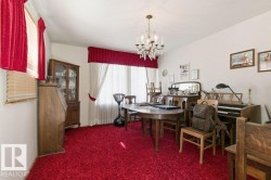 The room features red carpeting, white walls, and a chandelier - 