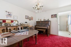 This room features white walls, a visible doorway, and a chandelier light fixture - 